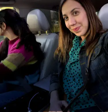 Smiling woman seated in car who has just talked to her doctor about endometriosis pain and treatment. Not an actual patient.
